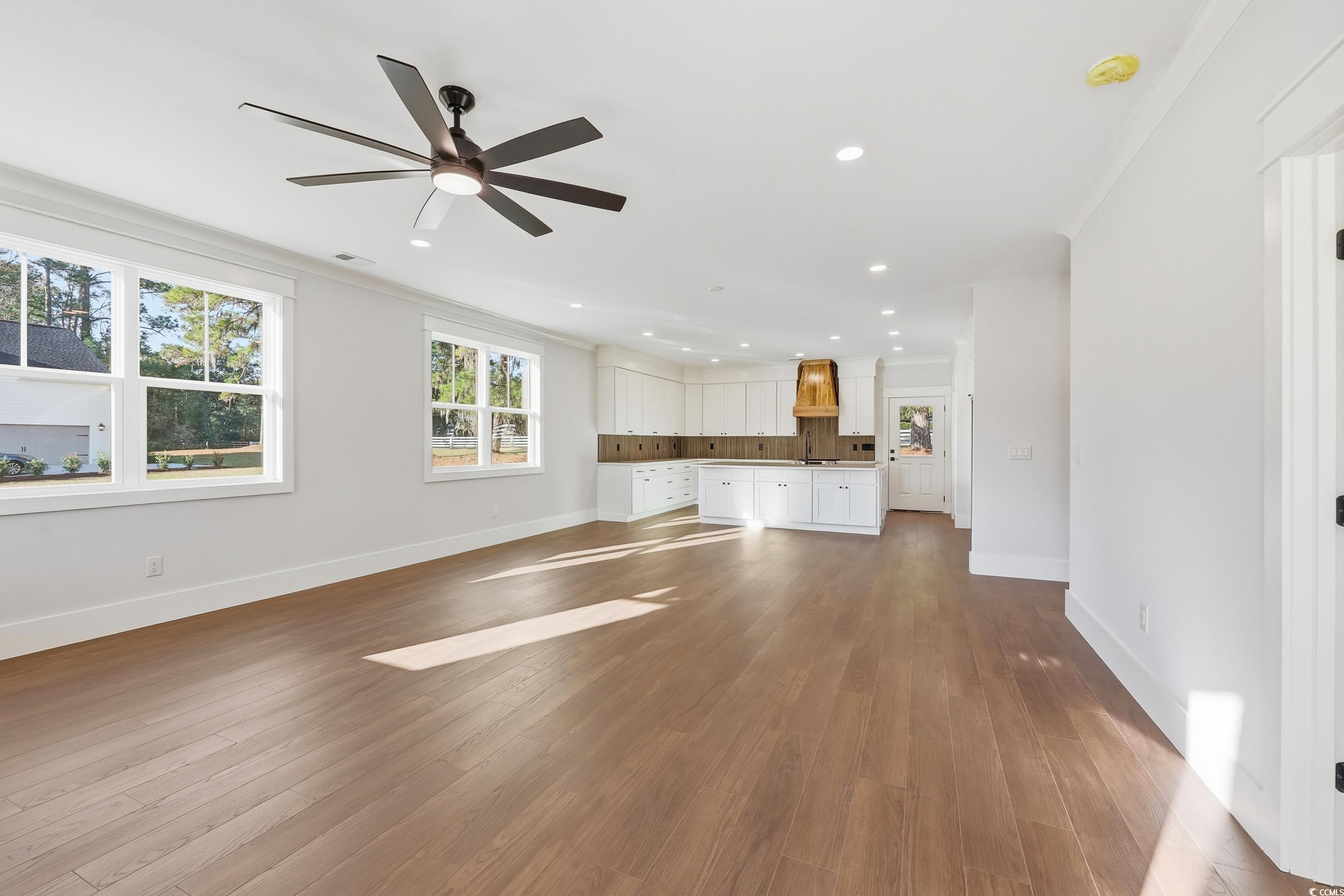 813 Commanders Island Road Georgetown, SC 29440 - Photo 4 of 39 Unfurnished living room with dark wood-style flooring, plenty of natural light, recessed lighting, ceiling fan, and crown molding