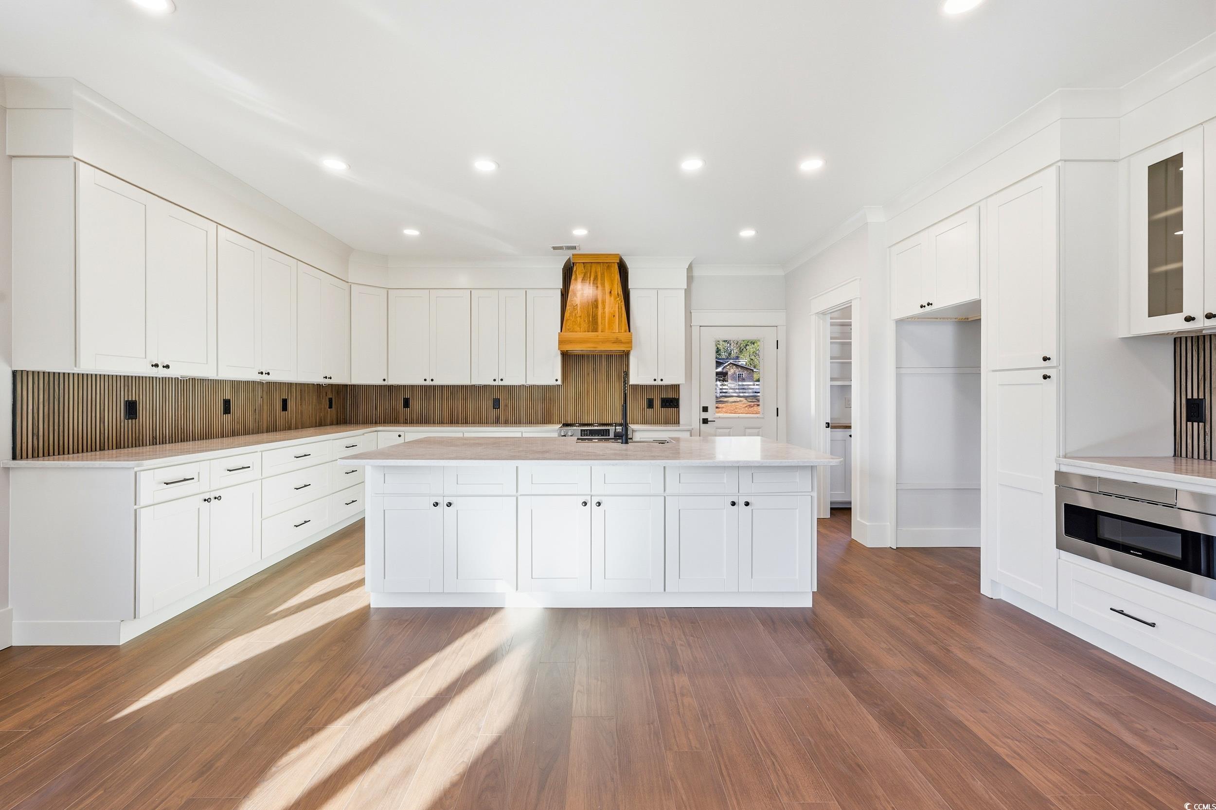 813 Commanders Island Road Georgetown, SC 29440 - Photo 6 of 39 Kitchen with white cabinets, a center island with sink, dark wood-type flooring, recessed lighting, and crown molding