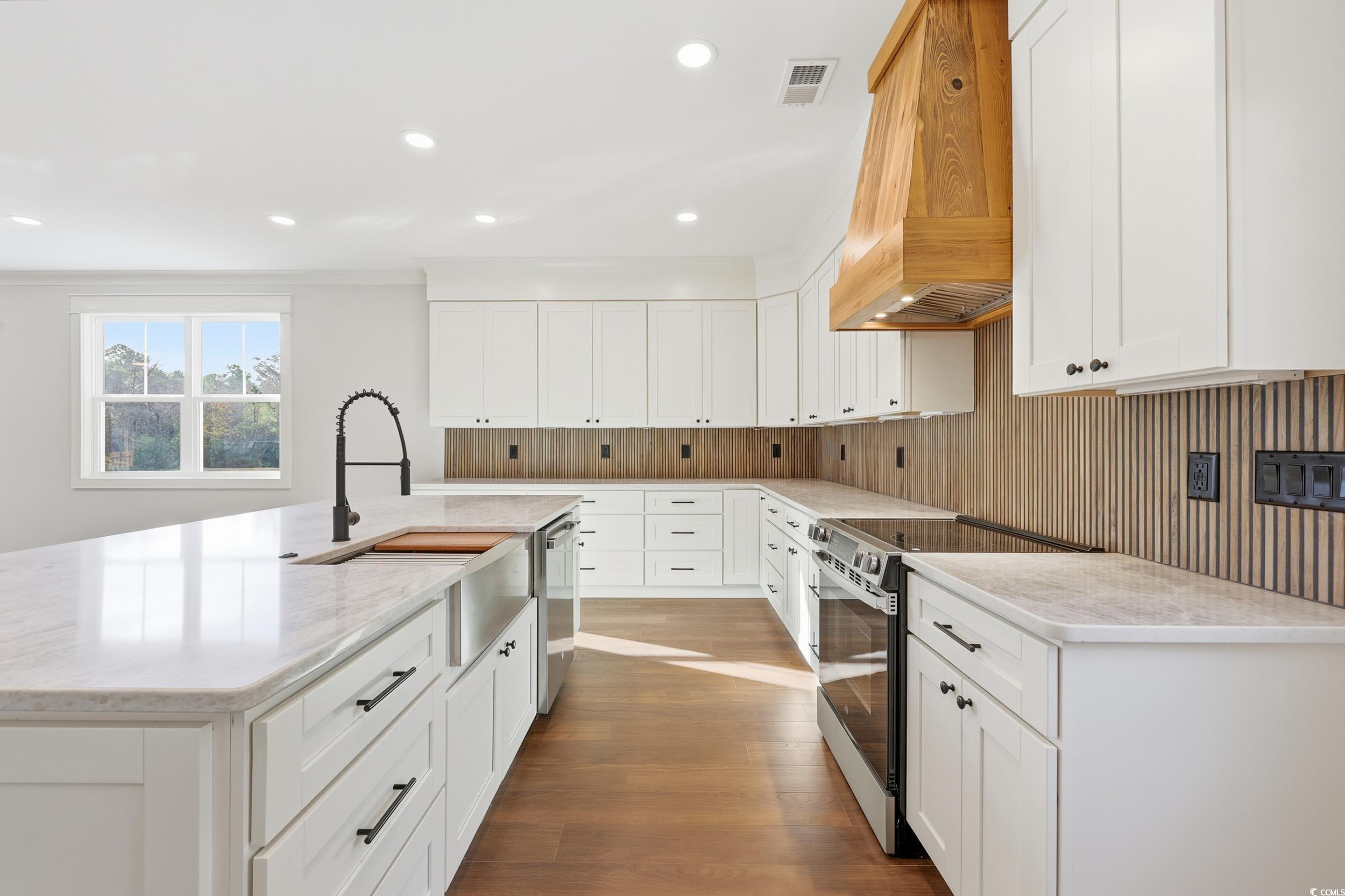 813 Commanders Island Road Georgetown, SC 29440 - Photo 7 of 39 Kitchen featuring white cabinetry, appliances with stainless steel finishes, an island with sink, custom exhaust hood, and recessed lighting
