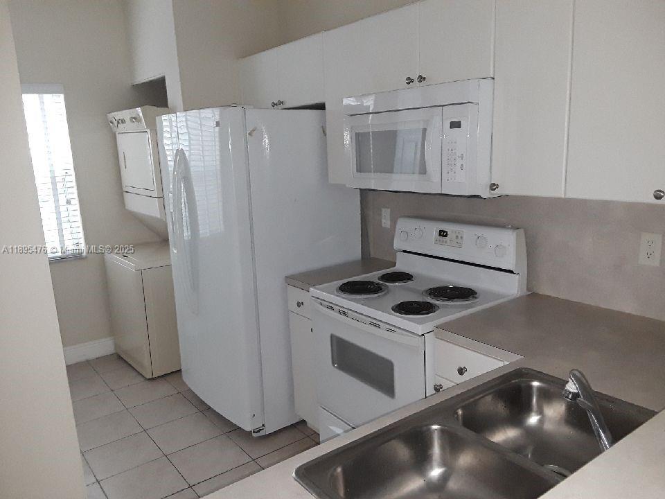 2322 Southeast 23rd Road, Unit 2322 Homestead, FL 33035 - Photo 4 of 11 a kitchen with white cabinets and white appliances