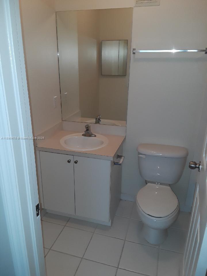 2322 Southeast 23rd Road, Unit 2322 Homestead, FL 33035 - Photo 7 of 11 a bathroom with a toilet sink and mirror