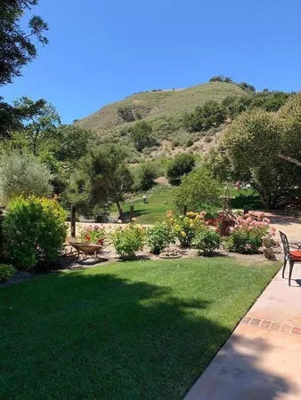 a view of green field with mountains in the background