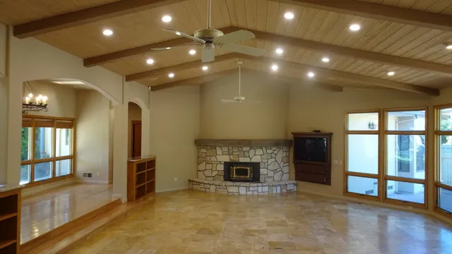 a view of an empty room with a fireplace and a window
