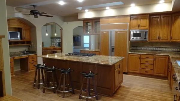 a kitchen with kitchen island granite countertop wooden cabinets and counter space