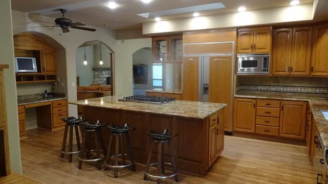 a kitchen with kitchen island granite countertop wooden cabinets and counter space
