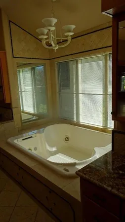 a bathroom with a granite countertop sink and a bathtub