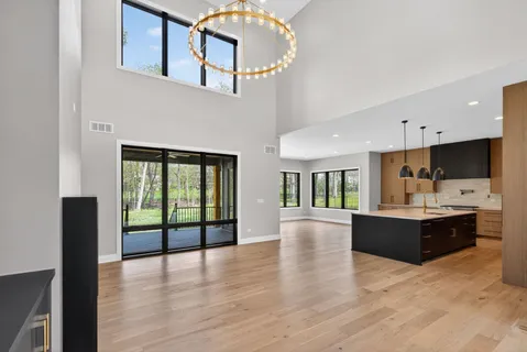 a view of large kitchen with kitchen island wooden floor and stainless steel appliances