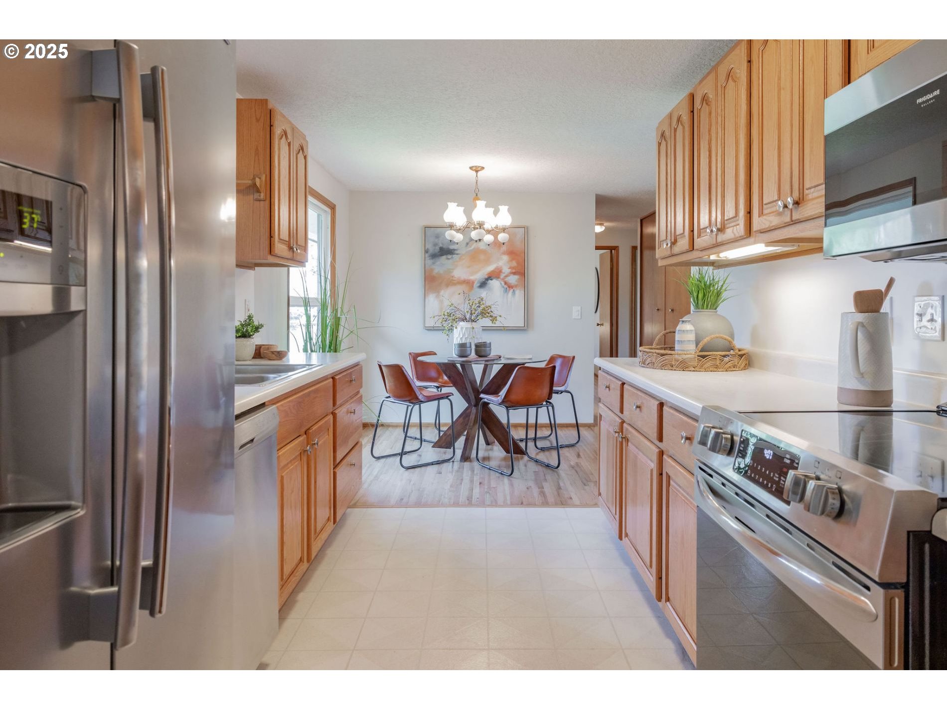 75 Northwest 22nd Street Gresham, OR 97030 - Photo 12 of 32 a kitchen with stainless steel appliances granite countertop a stove top oven a sink dishwasher a dining table and chairs with wooden floor
