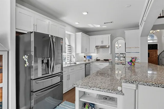 a kitchen with a refrigerator a sink and cabinets