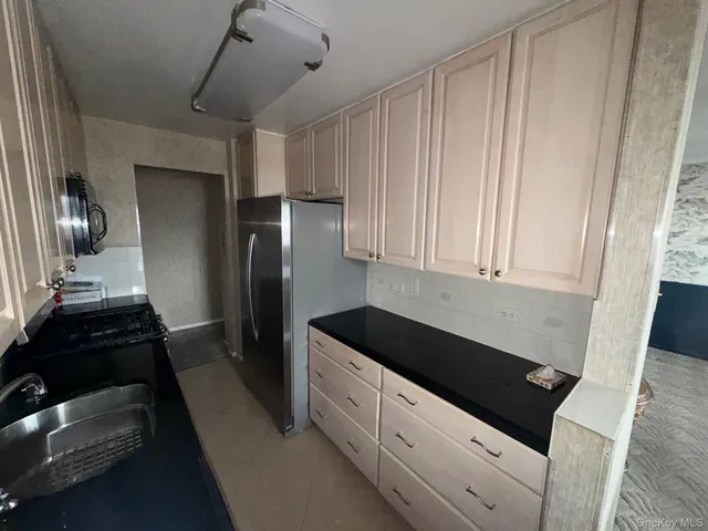 a kitchen with granite countertop a refrigerator and a sink