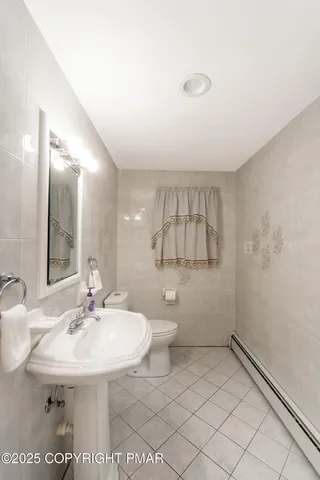 a bathroom with a sink a toilet and mirror