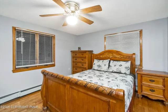 a bedroom with a bed and a dresser next to a window