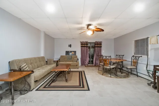 a living room with furniture a dining table and chairs with the view of kitchen