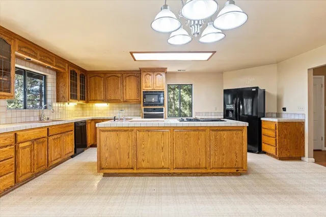 a large kitchen with stainless steel appliances granite countertop a stove and a sink