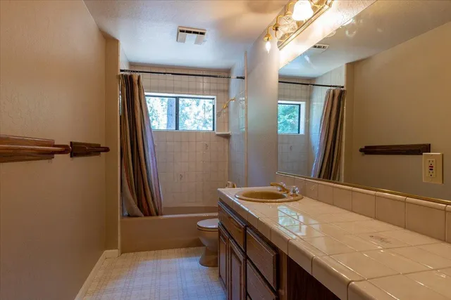 a kitchen with stainless steel appliances granite countertop a stove top oven a sink dishwasher and cabinets with wooden floor