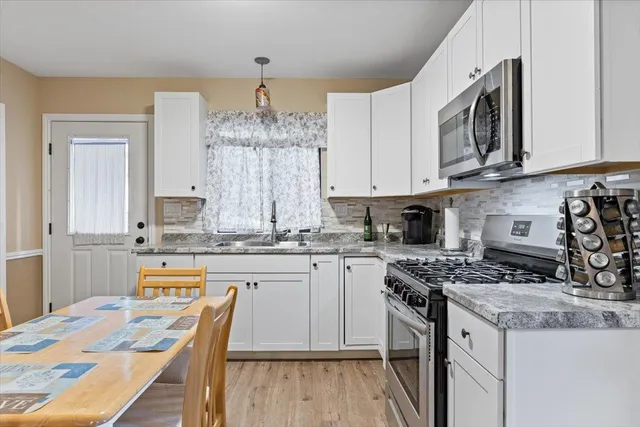 a view of a house with a yard and large trees