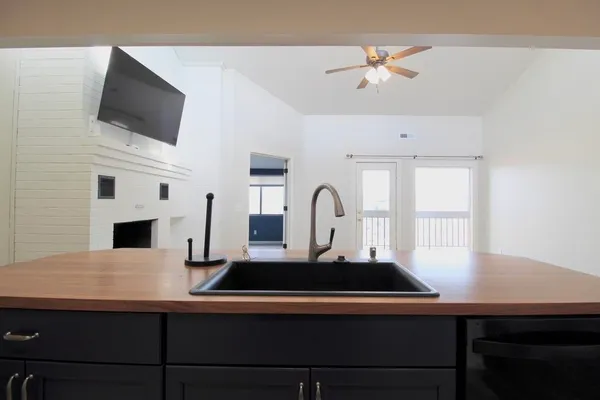 a kitchen with a stove a sink and a refrigerator with white cabinets