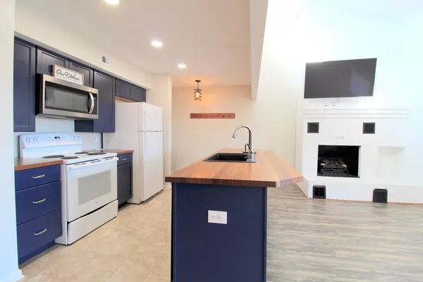 a kitchen with a sink a microwave and cabinets