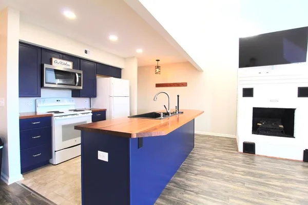 a large kitchen with stainless steel appliances kitchen island granite countertop a sink counter space and cabinets