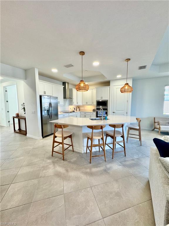 5376 Fancourt Links Way Ave Maria, FL 34142 - Photo 9 of 39 Kitchen featuring a breakfast bar area, stainless steel appliances, white cabinets, hanging light fixtures, and recessed lighting