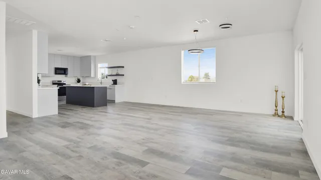 a view of a kitchen with a sink and dishwasher with wooden floor