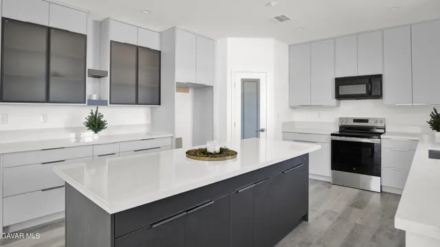 a kitchen with microwave cabinets and stove top oven