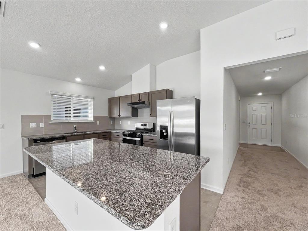 55 Signet Circle Flagler Beach, FL 32136 - Photo 21 of 39 a kitchen with stainless steel appliances granite countertop a sink stove and refrigerator