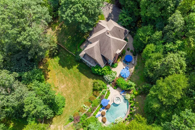an aerial view of a house with swimming pool and garden space