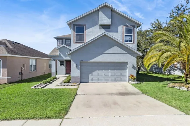 a front view of a house with a yard and garage