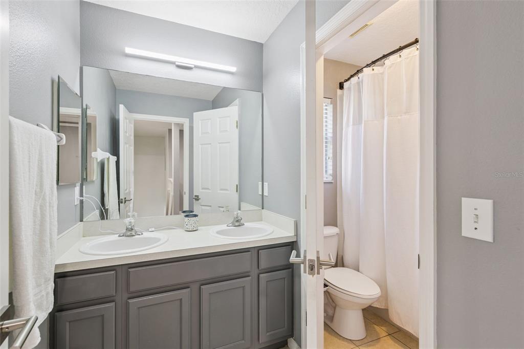 2718 Curpin Lane Orlando, FL 32825 - Photo 15 of 36 a bathroom with a double vanity sink toilet and a mirror