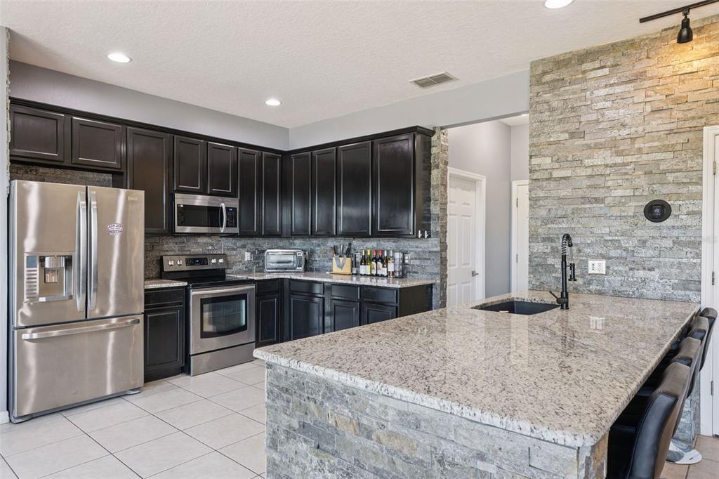 2718 Curpin Lane Orlando, FL 32825 - Photo 6 of 36 a kitchen with stainless steel appliances granite countertop a sink stove and refrigerator