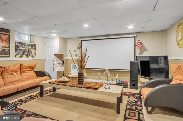 a view of a patio with table and chairs and potted plants and large tree