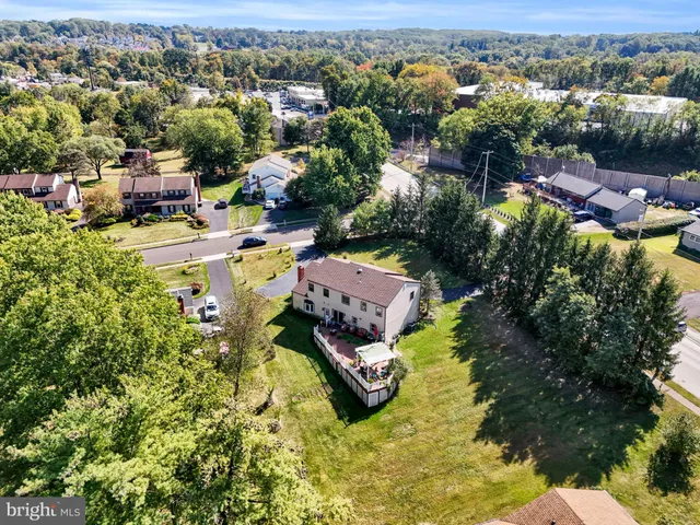 a aerial view of a house with swimming pool and large trees