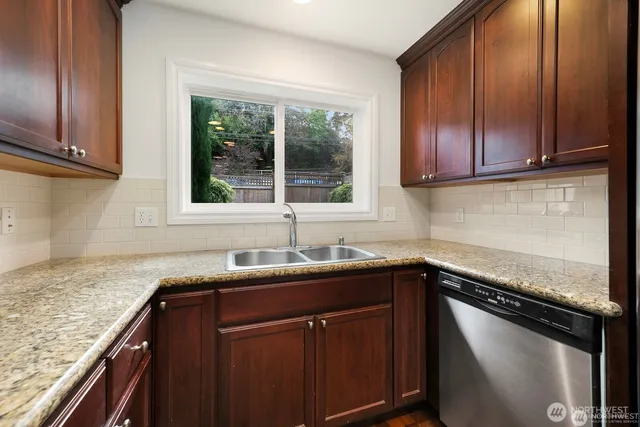 a kitchen with granite countertop cabinets sink and window