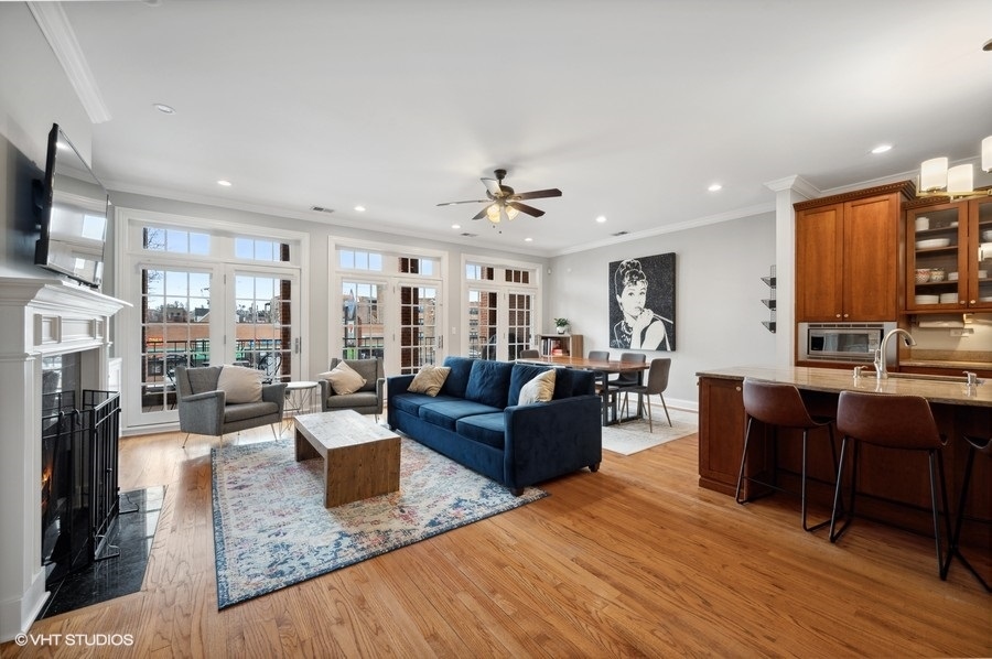 1414 West Irving Park Road, Unit 2E Chicago, IL 60613 - Photo 2 of 19 a living room with furniture a fireplace and a flat screen tv