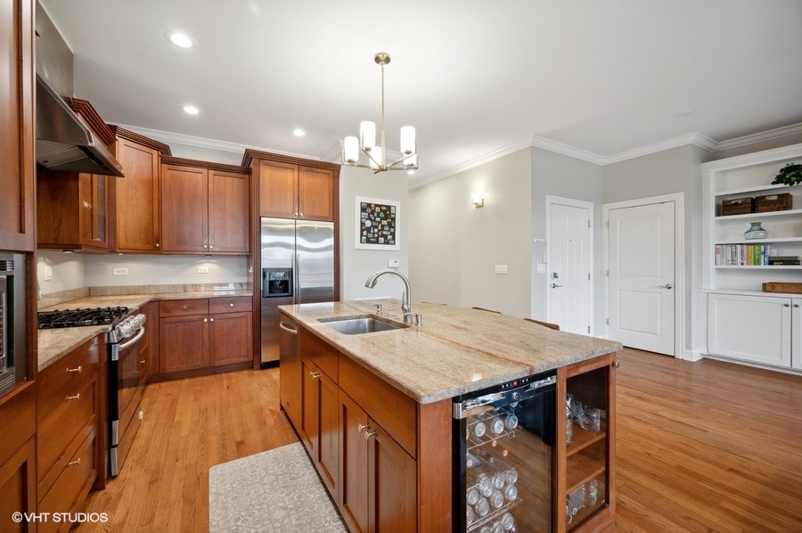 1414 West Irving Park Road, Unit 2E Chicago, IL 60613 - Photo 6 of 19 a kitchen that has a lot of cabinets and wooden floor