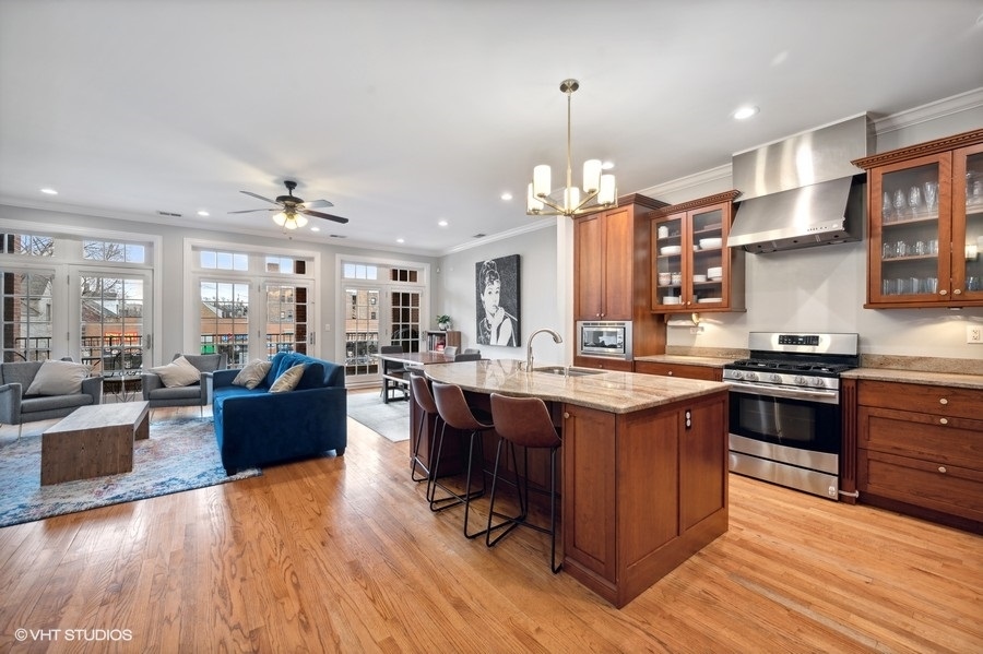 1414 West Irving Park Road, Unit 2E Chicago, IL 60613 - Photo 7 of 19 a large kitchen with lots of counter space a sink appliances and living room view