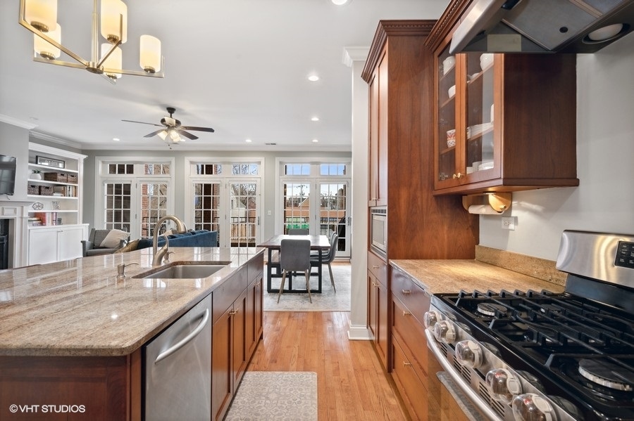 1414 West Irving Park Road, Unit 2E Chicago, IL 60613 - Photo 8 of 19 a kitchen with granite countertop a stove and cabinets