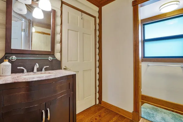 a bathroom with a granite countertop sink and a mirror