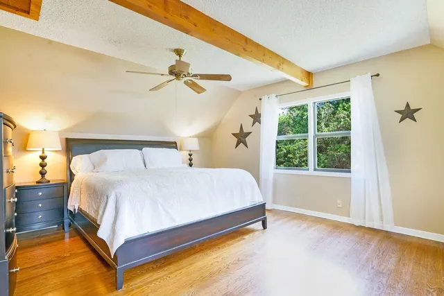 a spacious bedroom with a bed and a window