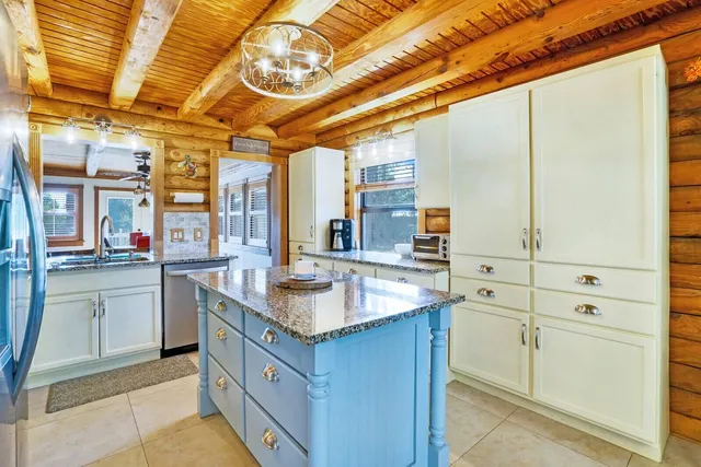 a kitchen with stainless steel appliances granite countertop a sink and dishwasher with white cabinets