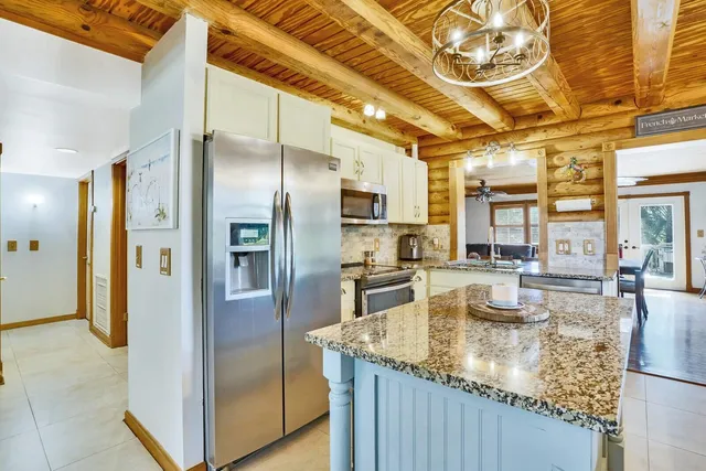 a kitchen with stainless steel appliances granite countertop a refrigerator a stove and a sink