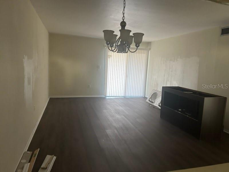 a view of a room with wooden floor and ceiling fan