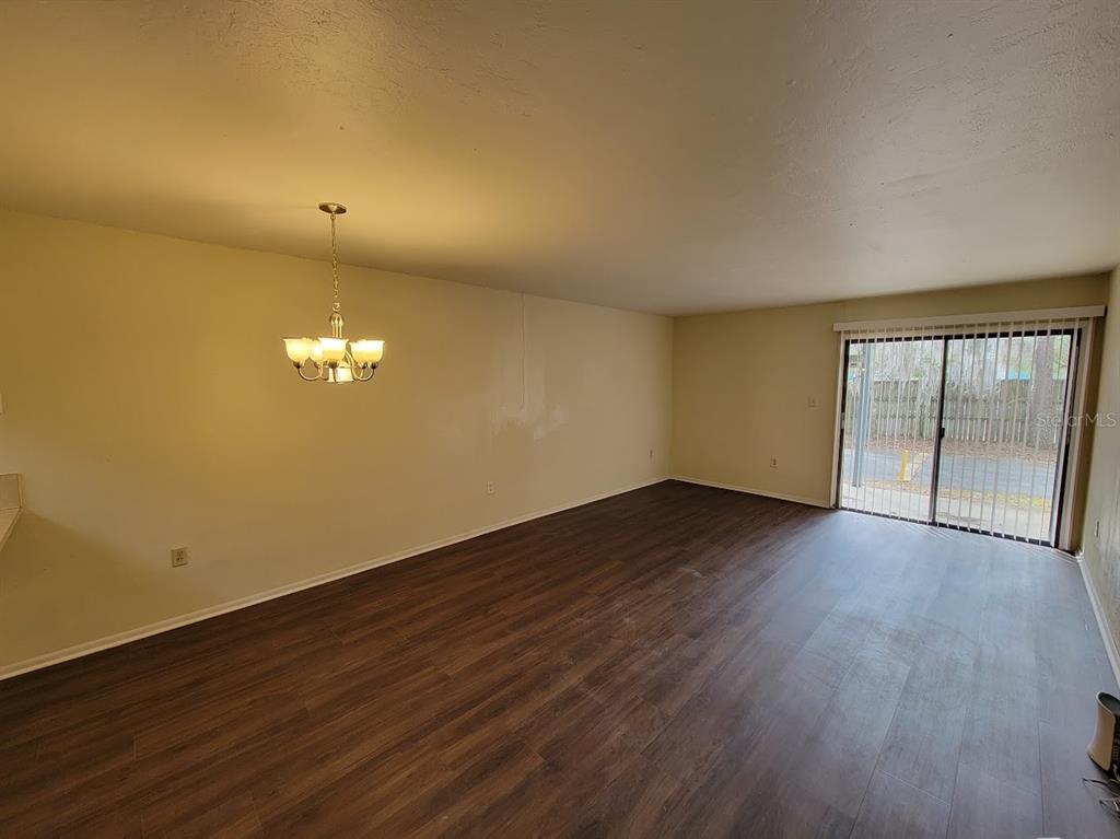 2811 Southwest Archer Road, Unit T167 Gainesville, FL 32608 - Photo 2 of 10 a view of an empty room with wooden floor and a window