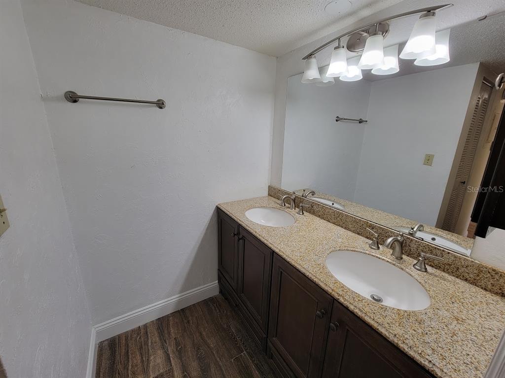 2811 Southwest Archer Road, Unit T167 Gainesville, FL 32608 - Photo 10 of 10 a bathroom with a granite countertop sink a large mirror and vanity