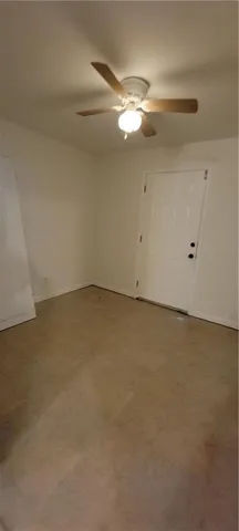 an empty room with a chandelier fan