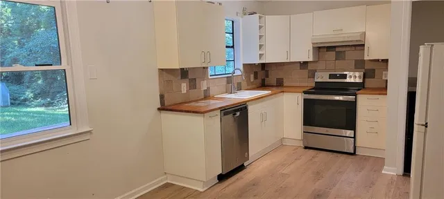 a kitchen with stainless steel appliances granite countertop a stove a sink and a refrigerator