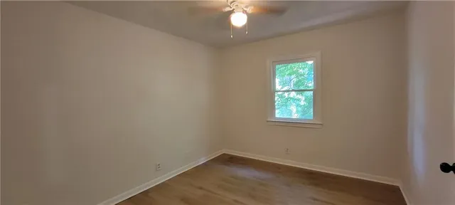 an empty room with a window and a fan