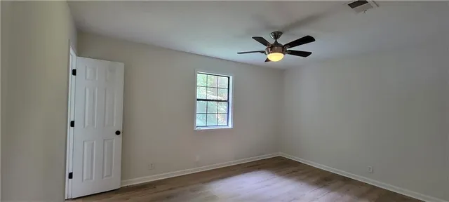 an empty room with a window and a ceiling fan
