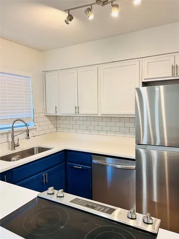 a kitchen with stainless steel appliances granite countertop a refrigerator and a sink